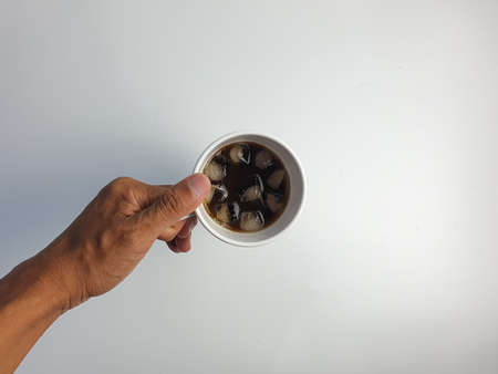 hand holding a cup of iced americano coffee, with copy space, isolated on a white background.の写真素材
