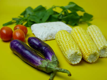 the concept of healthy food consists of eggplant, spinach, tomatoes, and corn. vegetarian food....