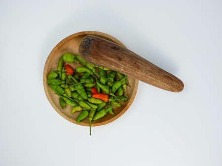 chilies on a wooden mortar isolated on a white backgroundの写真素材