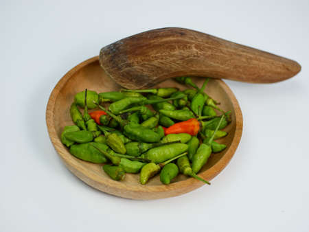 chilies on a wooden mortar isolated on a white backgroundの写真素材