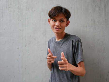 portrait of asian man with happy expression and hand pointingの写真素材