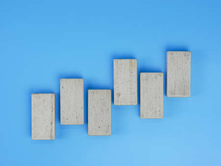 business up and down chart concept, wooden block isolated on blue backgroundの写真素材