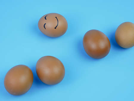 group of chicken eggs, one of which is a smiling face. the concept of innovation and leadershipの写真素材