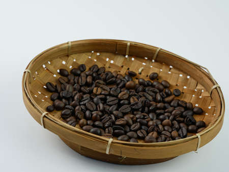 Quality coffee beans in bamboo basket isolated on white background.の写真素材