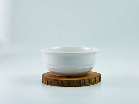 white bowl on wooden placemat isolated on white background.