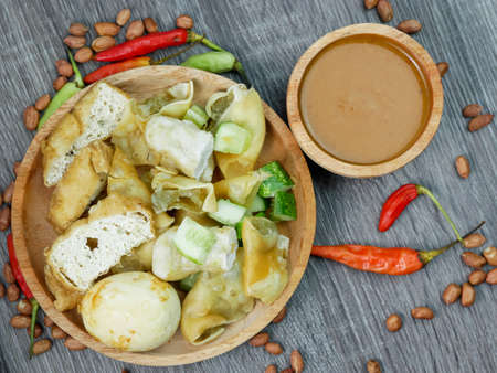 batagor or fried dumplings and peanut sauce with cayenne pepper and scattered peanuts.の写真素材