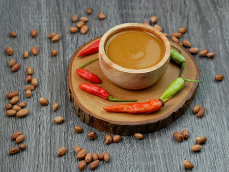 peanut sauce in a small wooden bowl on a gray wood texture background.の写真素材