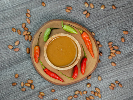 peanut sauce in a small wooden bowl on a gray wood texture background.の写真素材