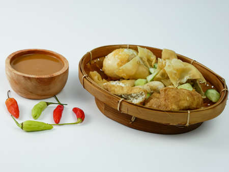 batagor or fried dumplings and peanut sauce with cayenne pepper. isolated on white background.の写真素材