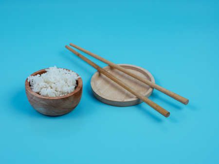 rice in a small wooden bowl and chopsticks.の写真素材