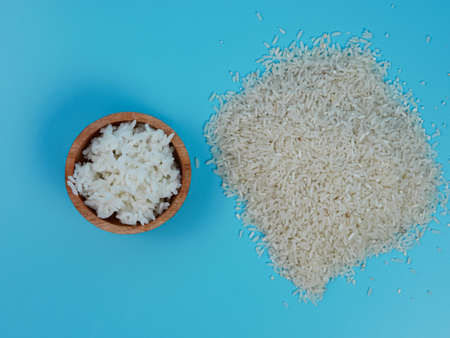 rice in a small wooden bowl and scattered rice.の写真素材