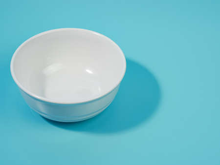 empty white bowl on blue background. minimalist style.