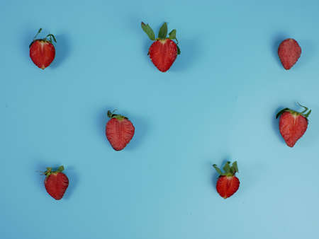 fresh strawberry slices on blue background. flat lay.の写真素材
