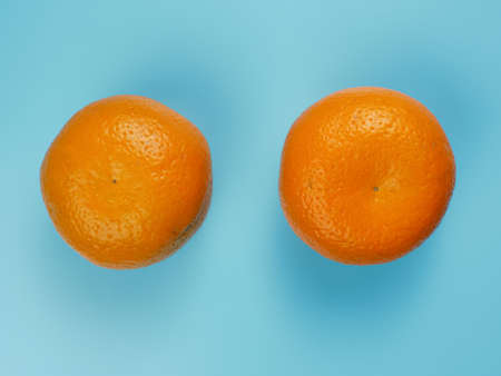 Creative concept made from oranges on blue pastel background. healthy and minimal fruit conceptの写真素材