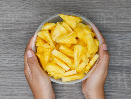 hand holding sliced fresh pineapple in a transparent container. healthy food and diet conceptの写真素材