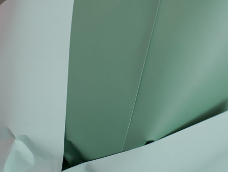 abstract background of green origami paper with curved corner and copy space