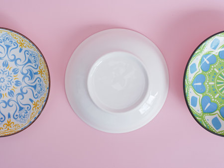 Top view of two porcelain plates and bowls on pink backgroundの写真素材