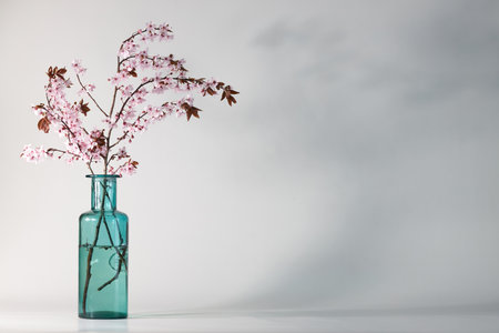 cherry blossom in a blue vase on a white background, on a left sideの写真素材