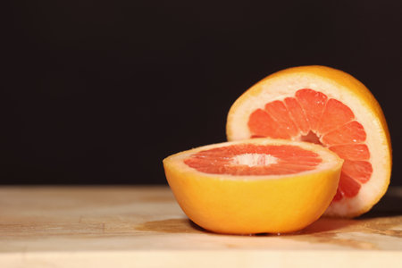 single grapefruit cut in half on a black backgroundの写真素材
