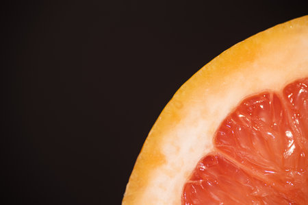 single grapefruit cut in half on a black background macro photageの写真素材