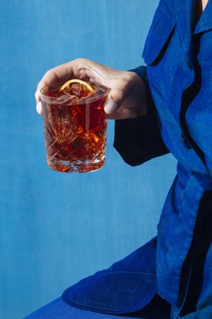 Woman and Negroni cocktail, with gin, bitter and vermouth. Colorful and trendy.の写真素材