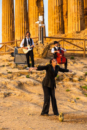 Artists perform after dusk at Concordia Temple in a summer sunny morningのeditorial素材