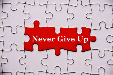 Never give up text on red background with missing jigsaw puzzle. Motivational conceptの写真素材