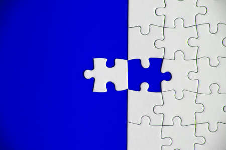 Top view of missing jigsaw puzzle on blue cover background. Copy space concept