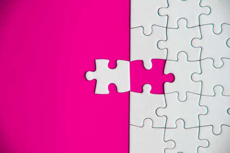 Top view of missing jigsaw puzzle on pink cover background. Copy space conceptの写真素材