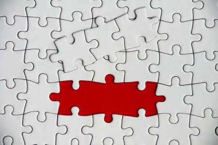 Top view of missing jigsaw puzzle on red cover background. Copy space conceptの写真素材