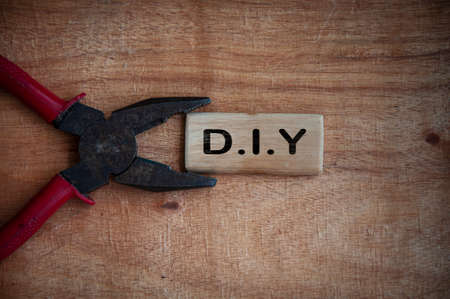 Text on wooden block - D.I.Y with working tool background. Do it yourself conceptの写真素材