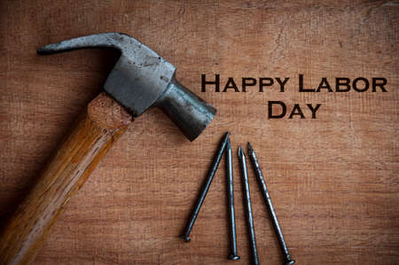 Top view of text on wooden desk - Happy Labor Day with hammer and nails background. Labor day conceptの写真素材