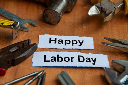 Happy labor day text on torn papers with working tools background. Labor day concept.の写真素材