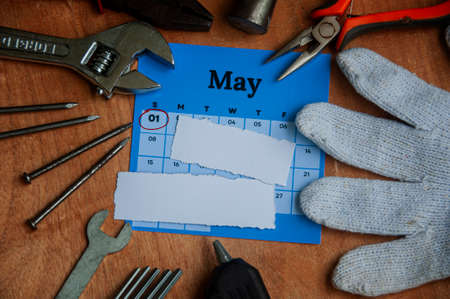 Top view of calendar and empty torn paper with working tools background. Copy space and labor day concept.の写真素材