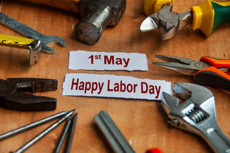 Happy labor day text on torn papers with working tools background. Labor day concept.の写真素材