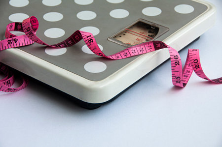 Measuring tape and weight scale on white background. Weight loss and fitness conceptの写真素材