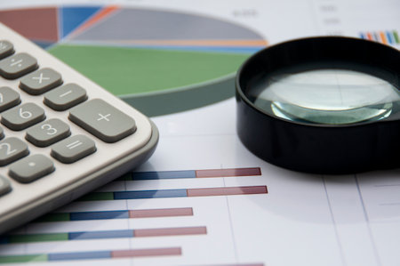 Analysis of data, chart and graphs with calculator and magnifying glass. Business finances and...