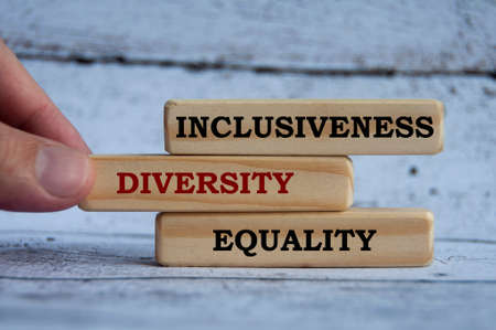 Inclusiveness, diversity and equality text on wooden blocks with wooden cover background. Business culture team conceptの写真素材
