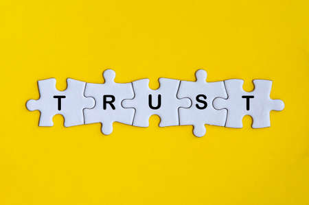 Word trust missing jigsaw puzzle on yellow cover background.の写真素材
