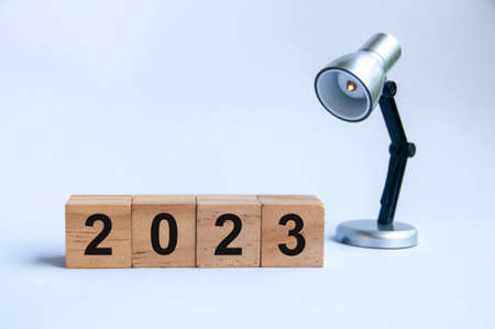 Year 2023 on wooden blocks with silver lamp background. New year concept 2023.の写真素材