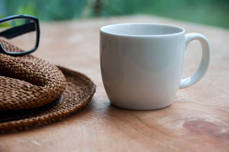 Travelling brown hat, glasses and coffee cup on wooden desk. Copy spaceの写真素材