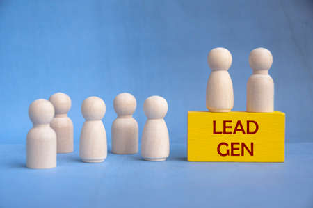 Lead Gen text on yellow wooden block with wooden dolls model on top. Online business conceptの写真素材