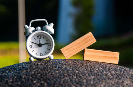 Alarm clock and wooden blocks with blurred background. Copy spaceの写真素材