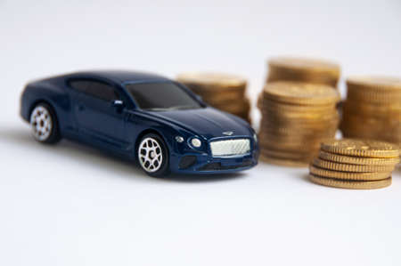 Kuala Lumpur, Malaysia - April 2022 : Miniature toy car of Bentley Continental GT with gold coin background. Copy spaceのeditorial素材