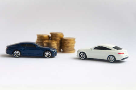 Kuala Lumpur, Malaysia - April 2022 : Miniature toy car of Mercedes AMG and Bentley Continental GT with gold coin background. Copy spaceのeditorial素材