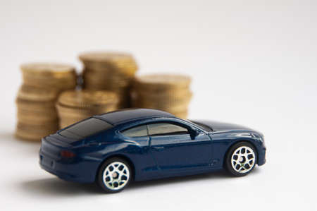 Kuala Lumpur, Malaysia - April 2022 : Miniature toy car of Bentley Continental GT with gold coin background. Copy spaceのeditorial素材