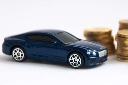 Kuala Lumpur, Malaysia - April 2022 : Miniature toy car of Bentley Continental GT with gold coin background. Copy spaceのeditorial素材