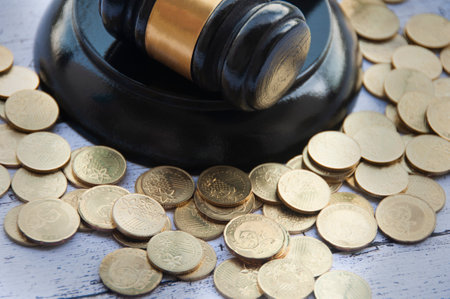Lawyer gavel on wooden table with gold coins. Law conceptの写真素材