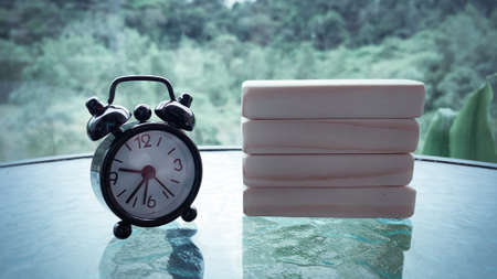 Black alarm clock with wooden blocks background. Copy spaceの写真素材