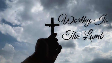 Christianity concept - Worthy is the Lamb with hand holding a Cross. Christian quote.